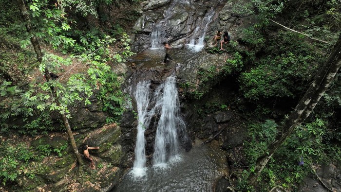 Foto udara pengunjung menikmati wisata air terjun Wonua Momahe, di Desa Waworaha, Kecamatan Soropia, Konawe, Sulawesi Tenggara, Minggu (25/6/2023). Tiga lokasi air terjun yang berada di Kawasan Taman Hutan Raya (Tahura) Nipa-nipa tersebut saat ini dikembangkan dalam Program Desa Wisata Kementerian Pariwisata dan Ekonomi Kreatif. ANTARA FOTO/Jojon/pras.