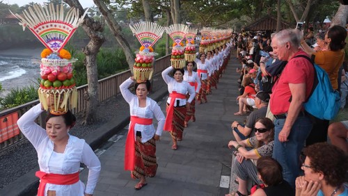 Sejumlah perempuan Bali menjunjung gebogan atau sesajen berisi buah, kue, bunga dan hiasan janur saat parade mapeed pada Tanah Lot Art and Food Festival IV di objek wisata Tanah Lot, Tabanan, Bali, Sabtu (24/6/2023). Kegiatan tersebut digelar sebagai daya tarik wisata guna meningkatkan jumlah kunjungan wisatawan di objek wisata itu yang saat ini jumlahnya rata-rata 8.000 orang per hari. ANTARA FOTO/Nyoman Hendra Wibowo/aww.