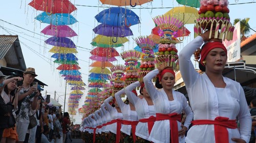 Sejumlah perempuan Bali menjunjung gebogan atau sesajen berisi buah, kue, bunga dan hiasan janur saat parade mapeed pada Tanah Lot Art and Food Festival IV di objek wisata Tanah Lot, Tabanan, Bali, Sabtu (24/6/2023). Kegiatan tersebut digelar sebagai daya tarik wisata guna meningkatkan jumlah kunjungan wisatawan di objek wisata itu yang saat ini jumlahnya rata-rata 8.000 orang per hari. ANTARA FOTO/Nyoman Hendra Wibowo/aww.