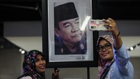 Warga berswafoto berlatar belakang foto Presiden pertama Republik Indonesia Ir. Soekarno yang dipajang pada pameran.  