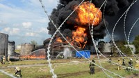 Anggota kementerian darurat bekerja memadamkan api di tangki bahan bakar yang terbakar di depot minyak di Voronezh, Rusia, Sabtu (24/6/2023). Lebih dari 100 petugas pemadam kebakaran dan 30 unit peralatan dikerahkan. 
