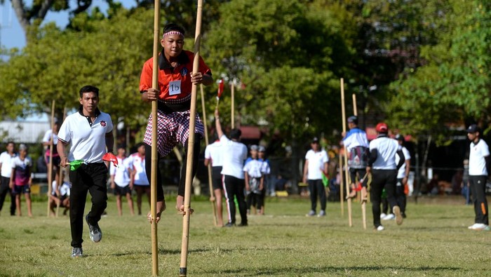 Potret Keseruan Lomba Olahraga Tradisional di Bali Pelajar beradu kecepatan di atas terompah panjang saat mengikuti lomba olahraga tradisional di kawasan Renon, Denpasar, Bali, Sabtu (24/6/2023). Kegiatan tersebut diselenggarakan untuk memperkenalkan dan melestarikan olahraga-olahraga tradisional kepada generasi muda. ANTARA FOTO/Fikri Yusuf/aww.