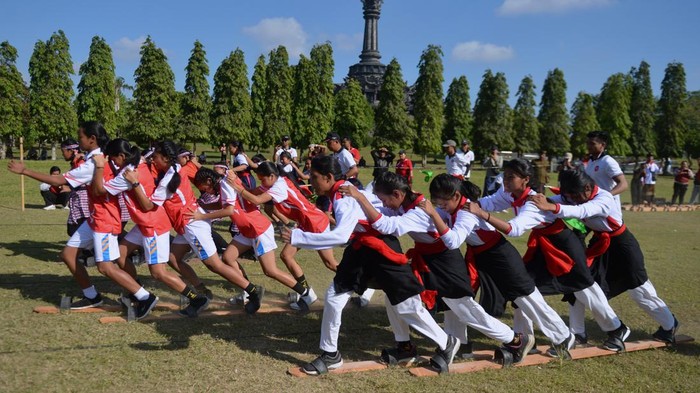 Potret Keseruan Lomba Olahraga Tradisional di Bali Pelajar beradu kecepatan di atas terompah panjang saat mengikuti lomba olahraga tradisional di kawasan Renon, Denpasar, Bali, Sabtu (24/6/2023). Kegiatan tersebut diselenggarakan untuk memperkenalkan dan melestarikan olahraga-olahraga tradisional kepada generasi muda. ANTARA FOTO/Fikri Yusuf/aww.