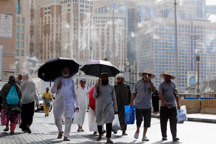 Men walk with umbrellas as people start arriving to perform the annual Haj in the Grand Mosque, in the holy city of Mecca, Saudi Arabia, June 24, 2023. REUTERS/Mohamed Abd El Ghany