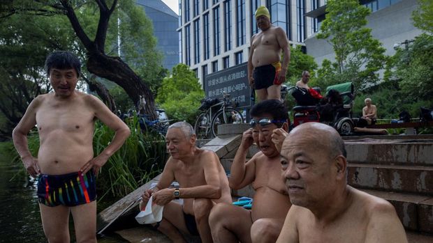 Warga China bertelanjang dada saat suhu panas menerjang. (REUTERS/THOMAS PETER)