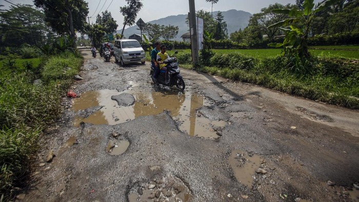 Pengendara melintasi jalan rusak yang ditanami pohon pisang di jalur wisata Puncak Dua, Sukamakmur, Kabupaten Bogor, Jawa Barat, Senin (26/6/2023). Jalan akses menuju sejumlah tempat wisata di kawasan Puncak Dua dan akses perbatasan Cianjur itu rusak dan membahayakan pengguna jalan. ANTARA FOTO/Yulius Satria Wijaya/tom.