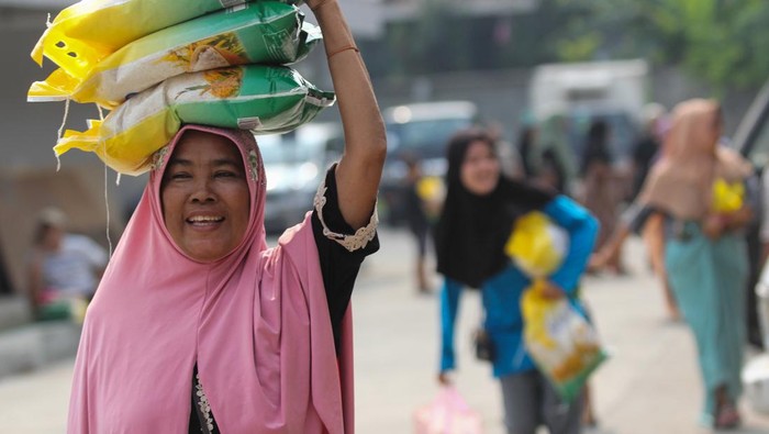 Warga membawa beras murah yang dibeli saat Gerakan Pangan Murah di Pasar Induk Surabaya Sidotopo (PISS), Surabaya, Jawa Timur, Senin (26/6/2023). Pemerintah menggelar Gerakan Pangan Murah dengan menjual berbagai bahan pangan yang dijual dengan harga lebih murah dari harga di pasaran sebagai upaya untuk menstabilkan pasokan dan harga bahan pangan menjelang Hari Raya Idul Adha. ANTARA  FOTO/Didik Suhartono/tom.