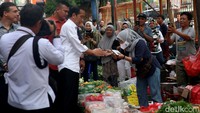 Tampak Jokowi membagikan bantuan ke masyarakat.