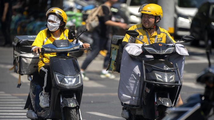 A delivery driver wears a face covering to protect themselves from the sun as they wait at an intersection on an unseasonably hot day in Beijing, Saturday, June 24, 2023. Authorities continued a rare red alert for high temperatures in parts of China's capital on Saturday, the highest level of warning, as highs were once again expected to climb to around 40 degrees Celsius (104 degrees Fahrenheit). (AP Photo/Mark Schiefelbein)