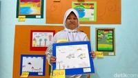 Rima (11) siswa kelas 4 SDN Haur Pancuh menunjukan karya gambar yang dibuatnya dengan judul ‘Pesawatku’. (Foto: Wisma Putra/detikJabar)