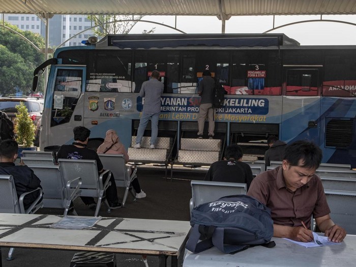 Pemilik kendaraan melakukan pembayaran pajak kendaraan bermotor di Pelayanan Samsat Keliling, Polda Metro Jaya, Jakarta, Senin (26/6/2023). Dalam rangka HUT DKI Jakarta ke-496, Pemprov DKI Jakarta melalui Bapenda menggelar keringanan pajak kendaraan yaitu Penghapusan sanksi administrasi secara jabatan untuk PKB dan Penghapusan bea balik nama kendaraan bermotor (BBNKB) yang dimulai sejak 22 Juni - 29 Desember 2023. ANTARA FOTO/Muhammad Adimaja/hp.