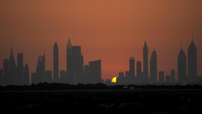 Terpikat Senja di Balik Gedung-gedung Tinggi Dubai The sun sets behind the Sheikh Zayed Highway towers, in Dubai, United Arab Emirates, Sunday, June 18, 2023. (AP Photo/Kamran Jebreili)