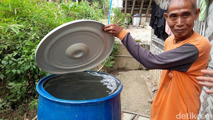 Warga menampung air keruh hasil serapan saluran irigasi di Brebes, Senin (26/6/2023).