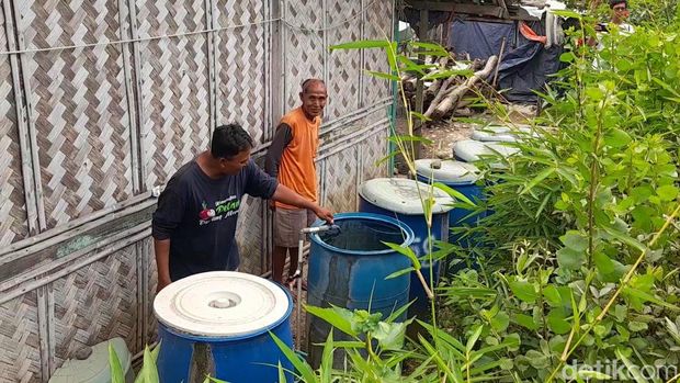 Warga menampung air keruh hasil serapan saluran irigasi di Brebes, Senin (26/6/2023).