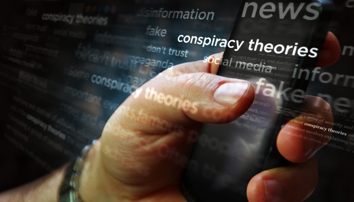 Social media on display with Conspiracy theories, hoax theory and fake news. Searching on tablet, pad, phone or smartphone screen in hand. Abstract concept of news titles 3d illustration.