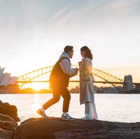 Keduanya terlihat berdiri di atas bebatuan, di depan pemandangan Opera House dan Jembatan Sydney Harbour. Foto: Instagram/@sinisukanthony