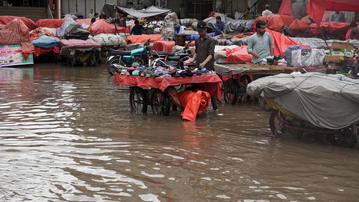 Belasan Orang Tewas Saat Banjir Rendam Pakistan Motorcyclists drive through a flooded road caused by heavy rainfall, in Lahore, Pakistan, Monday, June 26, 2023. (AP Photo/K.M. Chaudary)