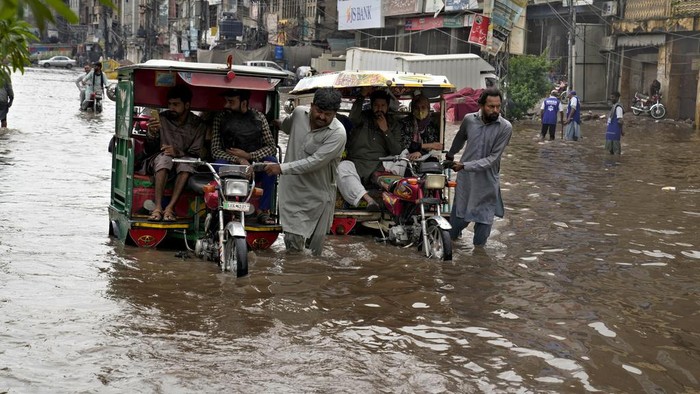 Motorcyclists drive through a flooded road caused by heavy rainfall, in Lahore, Pakistan, Monday, June 26, 2023. (AP Photo/K.M. Chaudary)