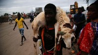 Seorang pria membawa domba di pasar domba menjelang Idul Adha, di Port-Bouet, Abidjan, Pantai Gading 26 Juni 2023. REUTERS/Luc Gnago.  