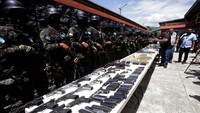 Anggota Polisi Militer Ketertiban Umum berjaga-jaga saat mereka menunjukkan peluru, magasin, dan senjata, yang disita dari penjara.  