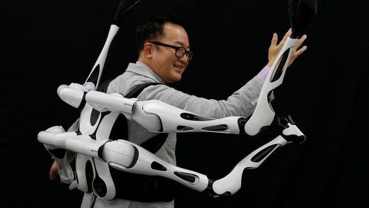 Masahiko Inami of the University of Tokyo poses with the wearable Jizai Arms robot arms at his lab during its demonstration in Tokyo, Japan, June 22, 2023. REUTERS/Kim Kyung-Hoon