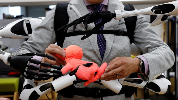 Masahiko Inami of the University of Tokyo poses with the wearable Jizai Arms robot arms at his lab during its demonstration in Tokyo, Japan, June 22, 2023. REUTERS/Kim Kyung-Hoon