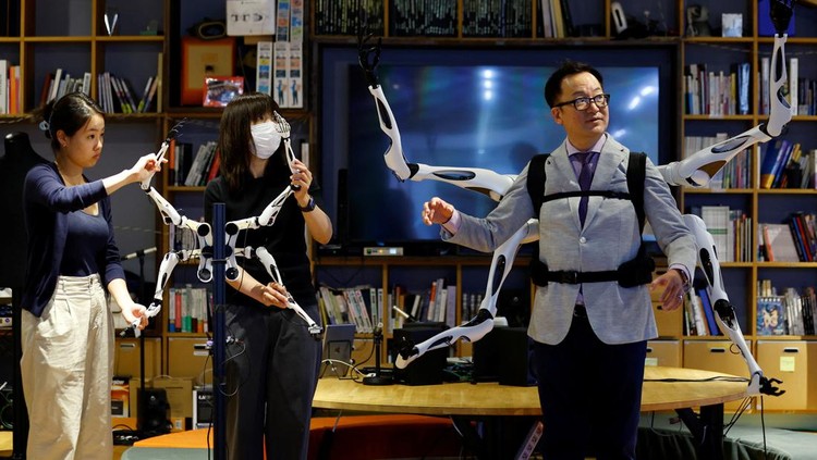 Masahiko Inami of the University of Tokyo poses with the wearable Jizai Arms robot arms at his lab during its demonstration in Tokyo, Japan, June 22, 2023. REUTERS/Kim Kyung-Hoon