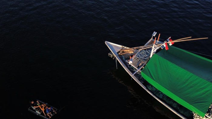 Foto udara beberapa nelayan berada diatas sampan disamping kapal nelayan berada di Teluk Kendari, Kendari, Senin (26/6/2023). Menyambut Hari Raya Idul Adha 1444 H nelayan setempat mengaku hingga empat hari kedepan tidak melaut. ANTARA FOTO/Jojon/hp.