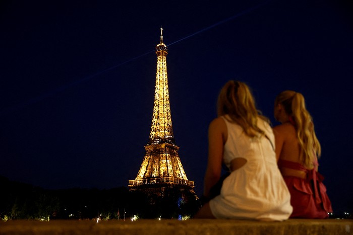 People sit on a bank of the River Seine near the Eiffel Tower in Paris, France, June 25, 2023. REUTERS/Benoit Tessier