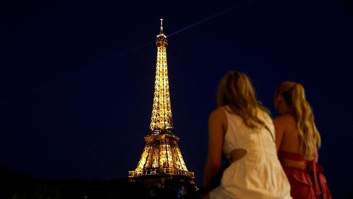 People sit on a bank of the River Seine near the Eiffel Tower in Paris, France, June 25, 2023. REUTERS/Benoit Tessier