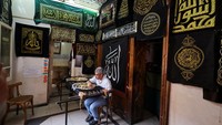 Penyulam Mesir Ahmed Shawki Othman al-Qasbagi menjahit sebuah ayat suci Alquran dengan benang emas, pada replika kiswah di galeri bengkelnya di distrik al-Hussein Islam Kairo, Mesir, Sabtu (24/6/2023).  