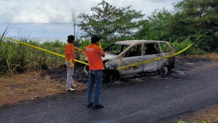 Petugas INAFIS Polres Kulon Progo melakukan identifikasi terhadap mobil gosong di jalan penghubung Pantai Glagah - Pantai Congot, Kapanewon Temon, Kulon Progo, Selasa (27/6/2023).