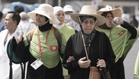 Peziarah Tunisia dengan topi jerami berjalan di luar Masjidil Haram, selama ziarah haji tahunan, di Mekkah. Saudi sedang dilanda suhu panas yang meningkat ketika sekitar dua juta jemaah haji dari seluruh dunia berkumpul di negaranya.