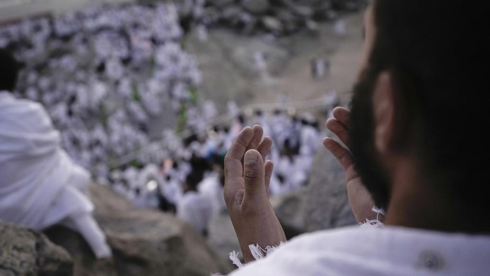 A Muslim pilgrim prays on the rocky hill known as the Mountain of Mercy, on the Plain of Arafat, during the annual Hajj pilgrimage, near the holy city of Mecca, Saudi Arabia, Tuesday, June 27, 2023. Around two million pilgrims are converging on Saudi Arabia's holy city of Mecca for the largest Hajj since the coronavirus pandemic severely curtailed access to one of Islam's five pillars. (AP Photo/Amr Nabil)