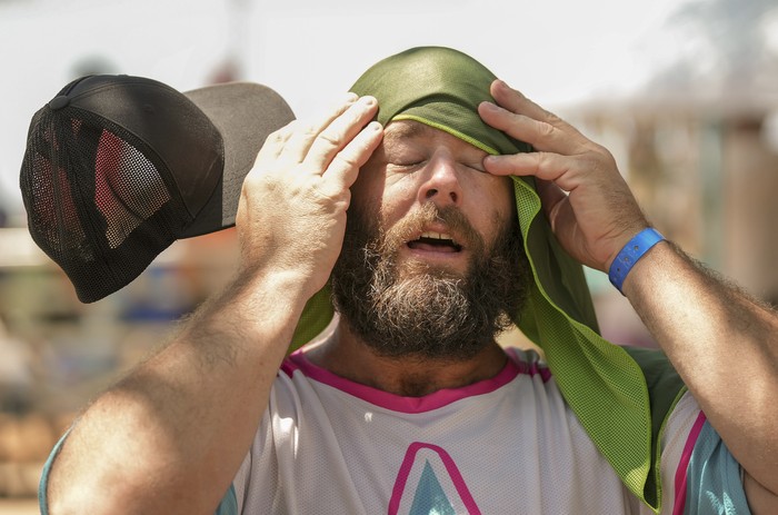 Shane Mullen, of Austin, cools off with a towel soaked in ice water at the Southwest Softball Association for the Deaf regional tournament at Walnut Creek Metropolitan Park in Austin, Texas, on a hot afternoon Friday June 23, 2023. Twenty-three teams from several states are competing in the event, which is one of the largest and longest-running deaf softball tournaments in the United States. (Jay Janner/Austin American-Statesman via AP)
