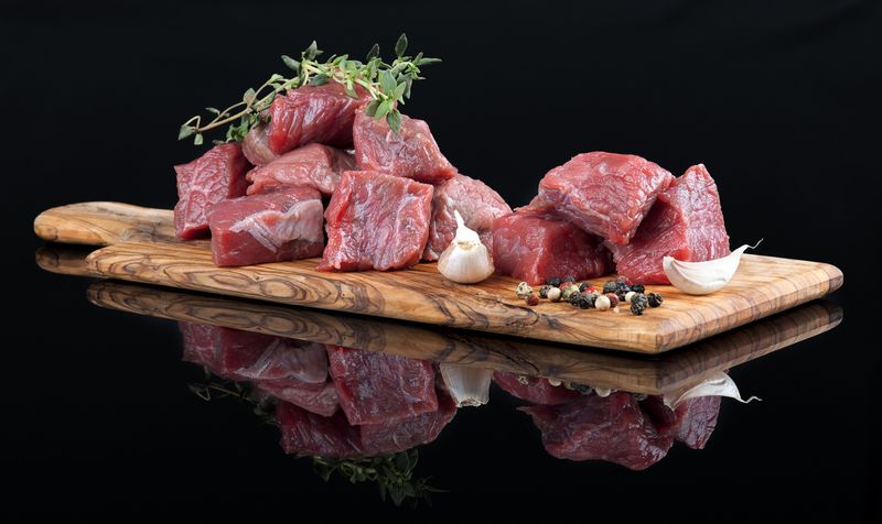 Red meat with reflection on black background.
