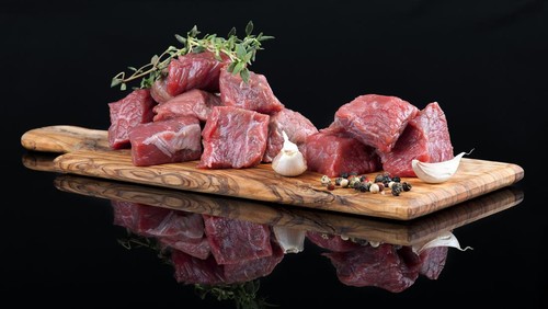 Red meat with reflection on black background.