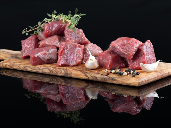 Red meat with reflection on black background.