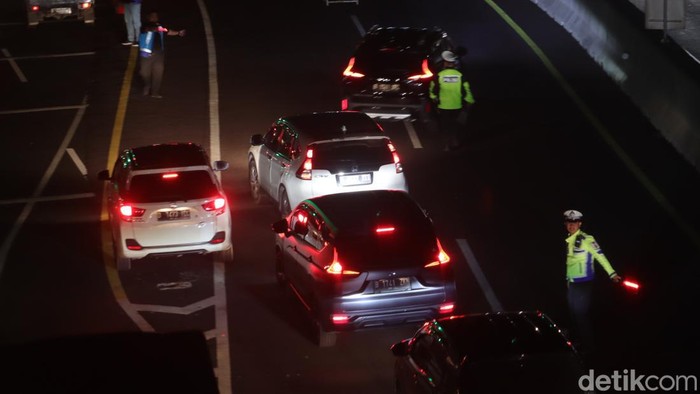 Anggota Satlantas Polresta Bandung mengatur arus lalin di Exit Tol Cileunyi, Rabu (28/6/2023) malam.