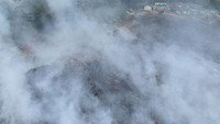 Kepulan asap tebal imbas kebakaran mengganggu jarak pandang dan kesehatan warga setempat.