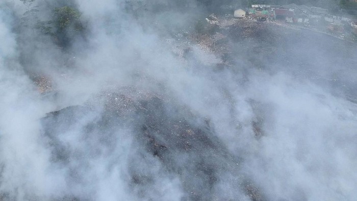 Foto aerial suasana kebakaran lahan sampah di Tempat Pembuangan Akhir (TPA) Desa Dermasuci, Kabupaten Tegal, Jawa Tengah, Selasa (27/6/2023). Menurut BPBD Kabupaten Tegal kebakaran yang menghanguskan meluas mencapai lima hektare lahan perbukitan sampah TPA sehingga mengakibatkan kepulan asap yang menganggu jarak pendang dan kesehatan warga setempat. ANTARA FOTO/Oky Lukmansyah/foc.