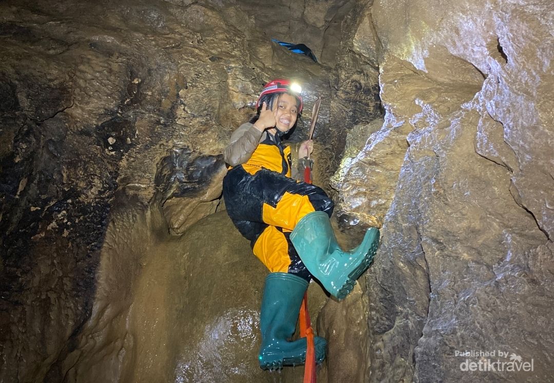 Memanjat dinding gua dengan bantuan webbing
