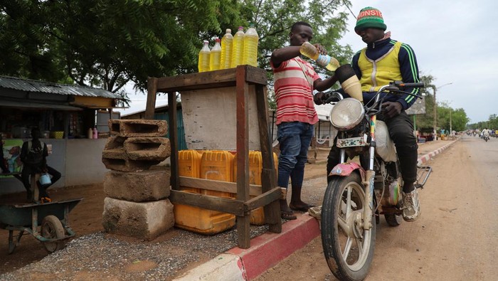 Nigeria Hapus Subsidi BBM Bikin 'Satu Benua' Sengsara Yaouba Ahmadou, in white dress, a semi-wholesaler of Nigeria's contraband fuel speaks with his workers in Garoua, Cameroon June 21, 2023. REUTERS/Desire Danga Essigue