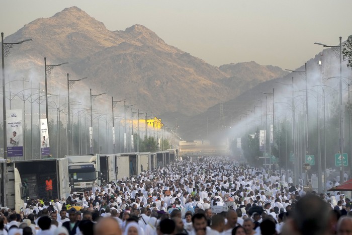 Water mist is sprayed on Muslim pilgrims as they pray on the rocky hill known as the Mountain of Mercy, on the Plain of Arafat, during the annual Hajj pilgrimage, near the holy city of Mecca, Saudi Arabia, Tuesday, June 27, 2023. Around two million pilgrims are converging on Saudi Arabias holy city of Mecca for the largest Hajj since the coronavirus pandemic severely curtailed access to one of Islams five pillars. (AP Photo/Amr Nabil)