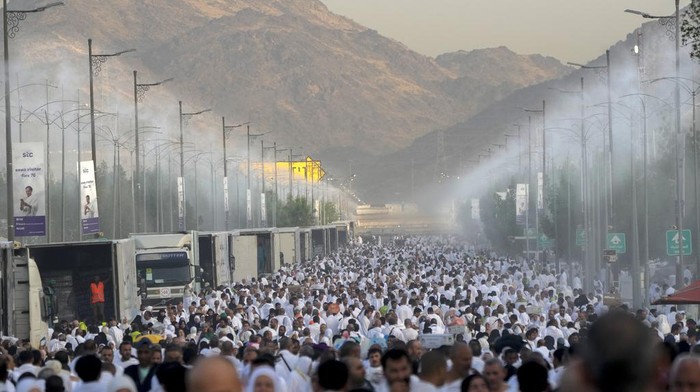 Water mist is sprayed on Muslim pilgrims as they pray on the rocky hill known as the Mountain of Mercy, on the Plain of Arafat, during the annual Hajj pilgrimage, near the holy city of Mecca, Saudi Arabia, Tuesday, June 27, 2023. Around two million pilgrims are converging on Saudi Arabias holy city of Mecca for the largest Hajj since the coronavirus pandemic severely curtailed access to one of Islams five pillars. (AP Photo/Amr Nabil)