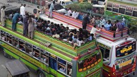 Warga menaiki atap bus di Lahore, Pakistan, Selasa (27/6/2023).