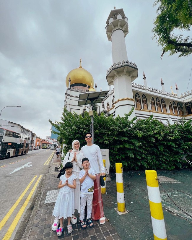 Keluarga Nycta Gina dan Rizky Kinos mengisi liburan Idul Adha dengan melancong ke Singapura bersama dua buah hatinya. Meski sambil liburan, mereka tetap melaksakan salat Ied di masjid setempat. Tampak Kinos berkaus putih yang dipadu dengan sarung merah. (Foto: Instagram)