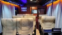 Geser ke bagian interior, menampilkan nuansa yang berbeda dari tampilan luarnya. Interior Big Benz Commander ini memiliki 8 kursi berukuran jumbo, yang bergaya ala captain seat dengan sandaran tangan, dan sudah dilengkapi bantal. Van ini juga memiliki sistem hiburan AVOD (Audio Video On Demand). Foto: Dok. Adiputro