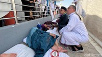 Di samping toilet ada sejumlah jemaah haji perempuan yang menggelar kasur dan tidur di sana. Mereka mengaku tak kebagian tempat di dalam tenda.
