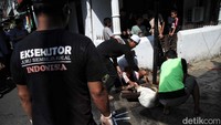 Petugas menyembelih kambing. Tidak seperti sapi, merebahkan kambing tergolong lebih mudah karena ukurannya yang kecil. 